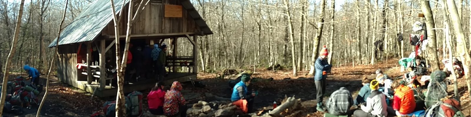 Group of hikers sitting outside the Stratton Mountain shelter in late fall