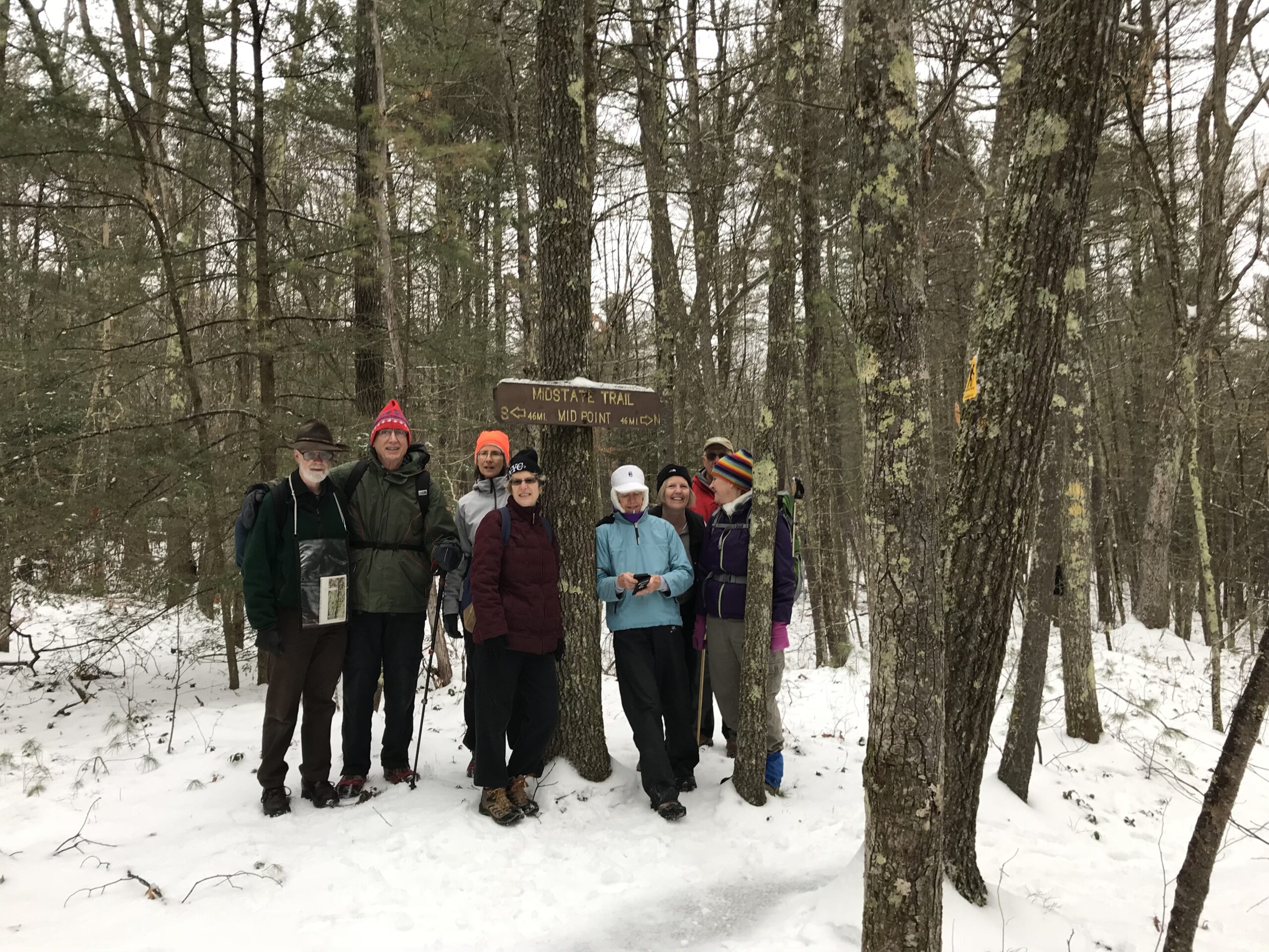 group photo of 7 people during winter hike on Midstate Trail in 2026